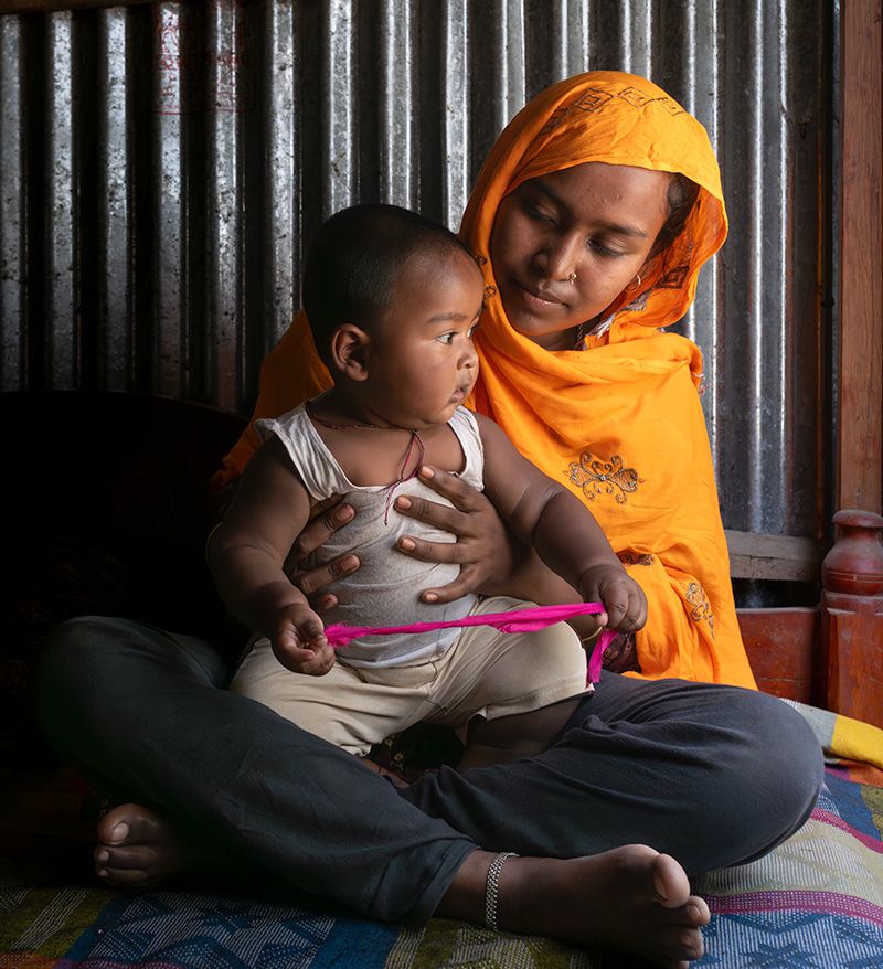 Shumi*, 21, with her nine-month-old son Irfan*, who was delivered with the help of Save the Children's Mamota Project in Gaibandha, Bangladesh | Photo: Fatima Tuj Johora / Save the Children