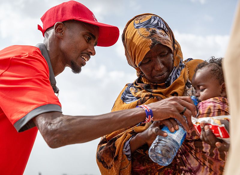 Save the Children Ambassador Sir Mo Farah meets Aisha and her malnourished son Hassan who is receiving treatment from Sabaad. | Photo: Mustafa Saeed / Save the Children