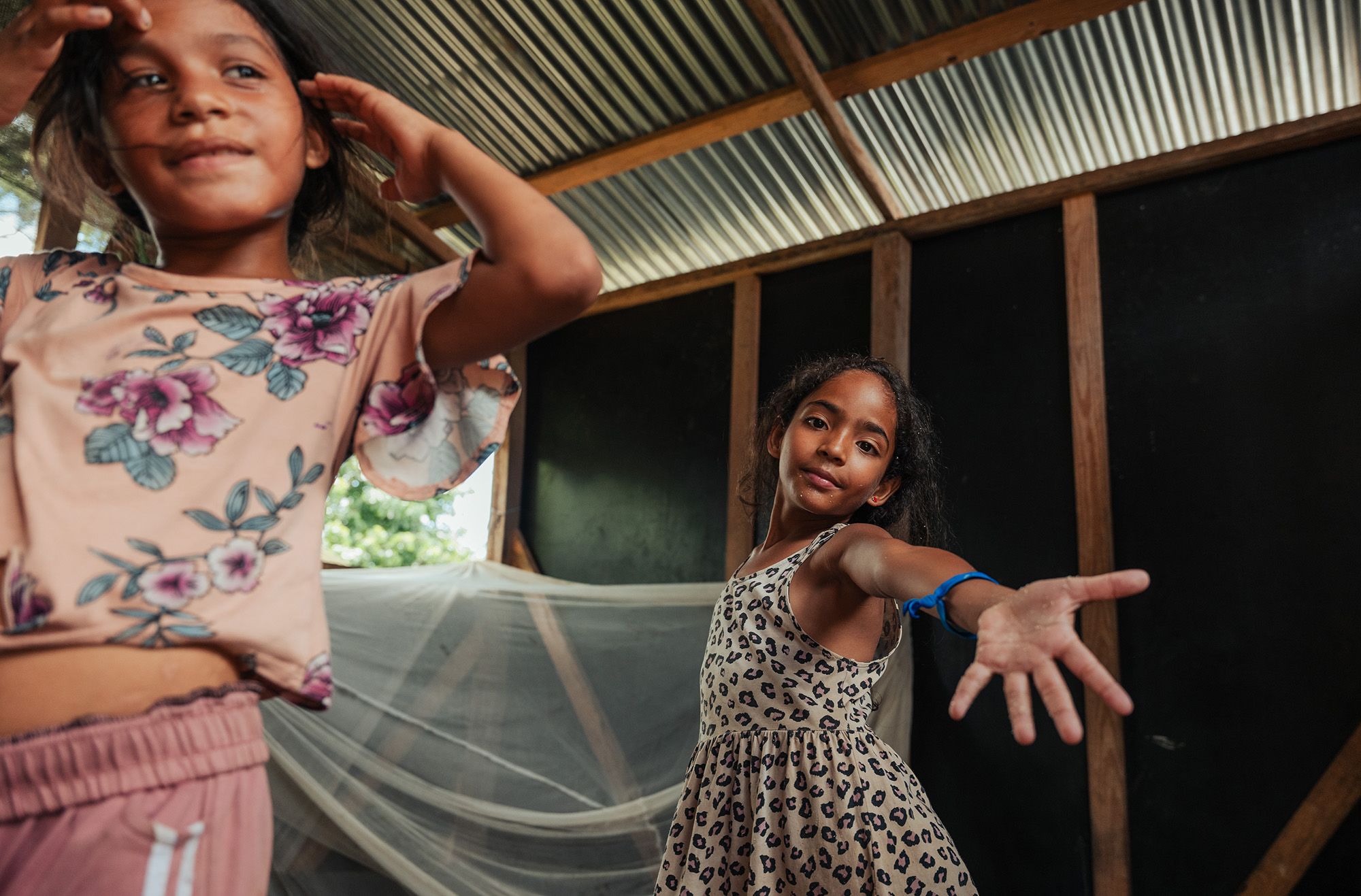 Coral*(8) and Alina*(7) dance inside their shelter | Photo: Adriana Loureiro Fernandez / Save the Children