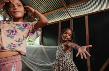 Coral*(8) and Alina*(7) dance inside their shelter | Photo: Adriana Loureiro Fernandez / Save the Children