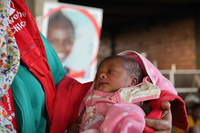Save the Children staff member holds newborn baby Sara* at mobile clinic, Sudan. | Photo: Mussab Hassona / Save the Children