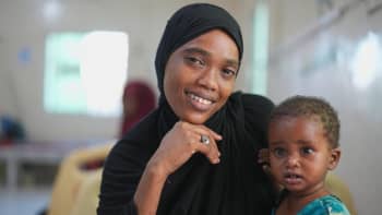 Amal* smiles warmly with recovering Fatma*, 12 months, at the Stabilization Centre, Bosaso, Puntland, Somalia | Photo: Ahmed Abdi / Save the Children